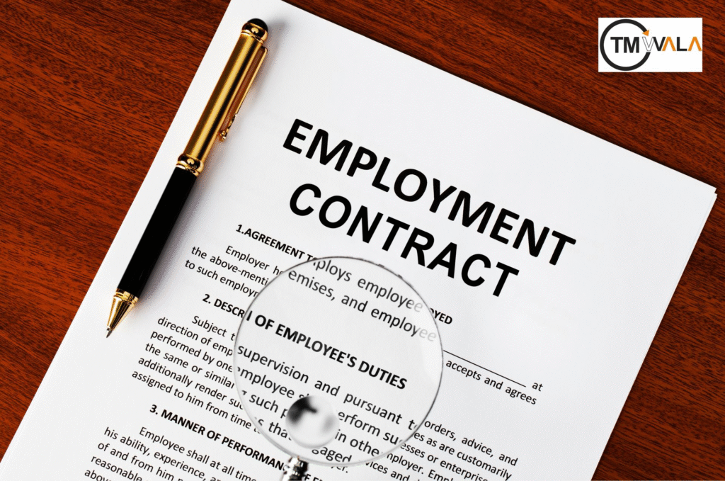 Employment contract document with pen and magnifying glass on wooden desk.